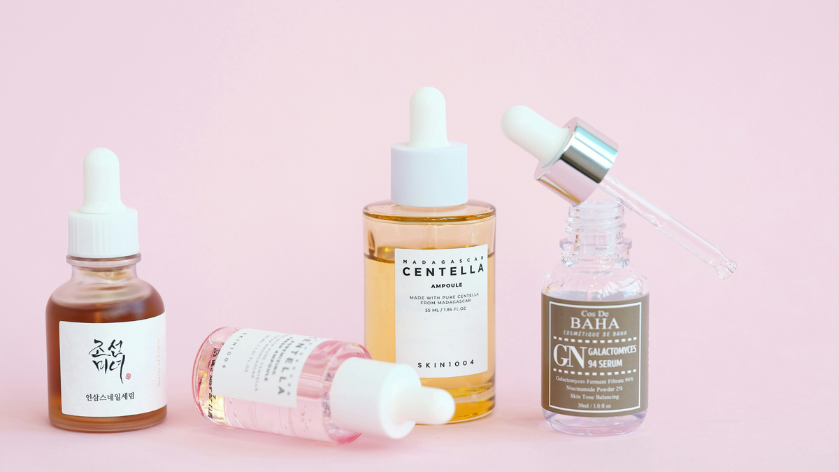 Vier Skincare Produkte nebeneinander vor einem rosa Hintergrund