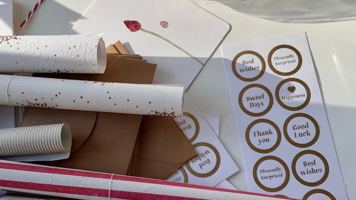 Verschiedene Sorten Geschenkpapier Rollen daneben Sticker