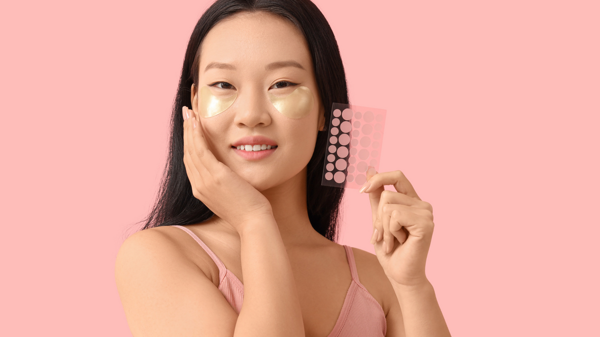 Junge Frau mit Augenpads hält Pimple Patches neben sich