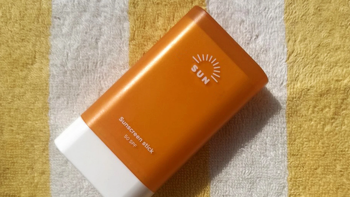 Nahaufnahme Sonnencreme Stick auf Strandtuch