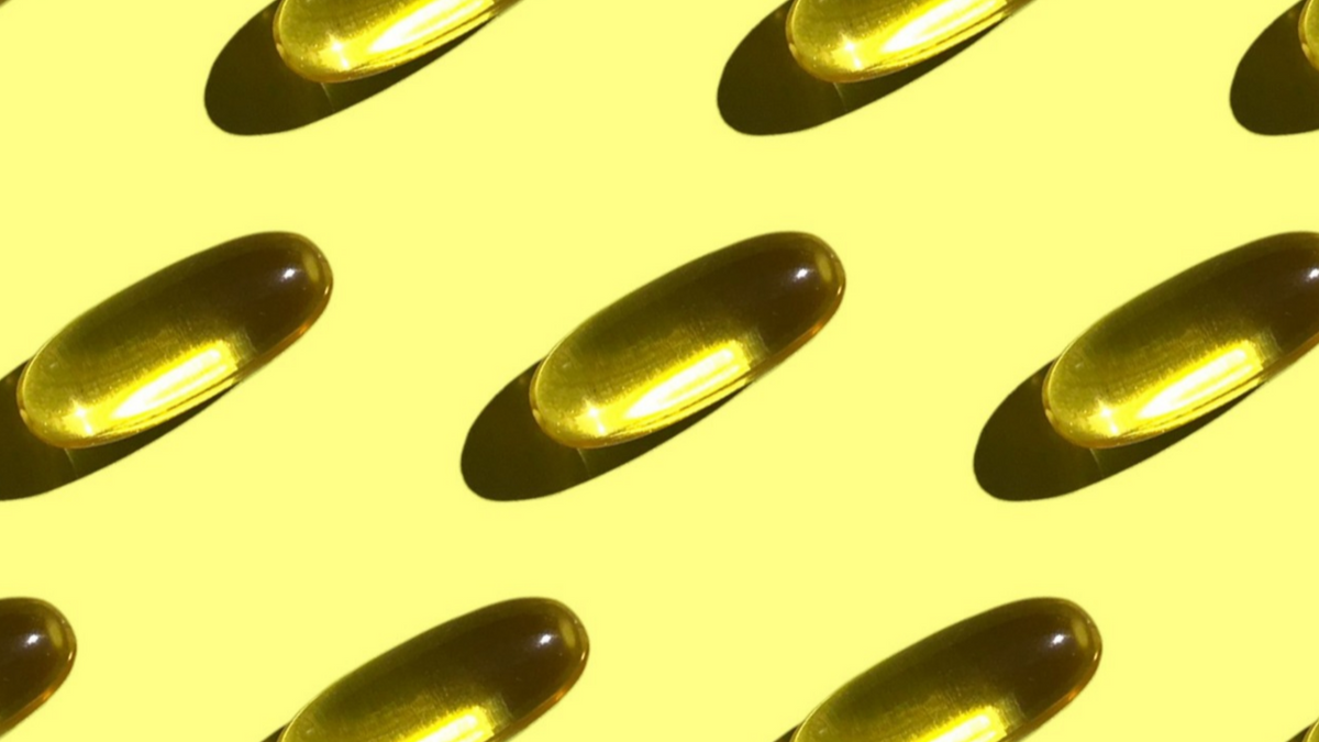 Vitamin Kapseln durchsichtig auf gelber Oberfläche