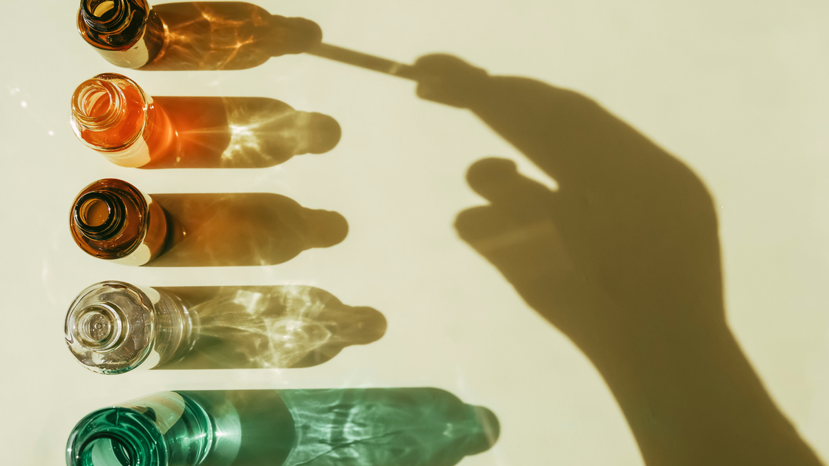 5 verschieden farbige Peptid falschen und eine Hand hält eine Pipette als Schatten