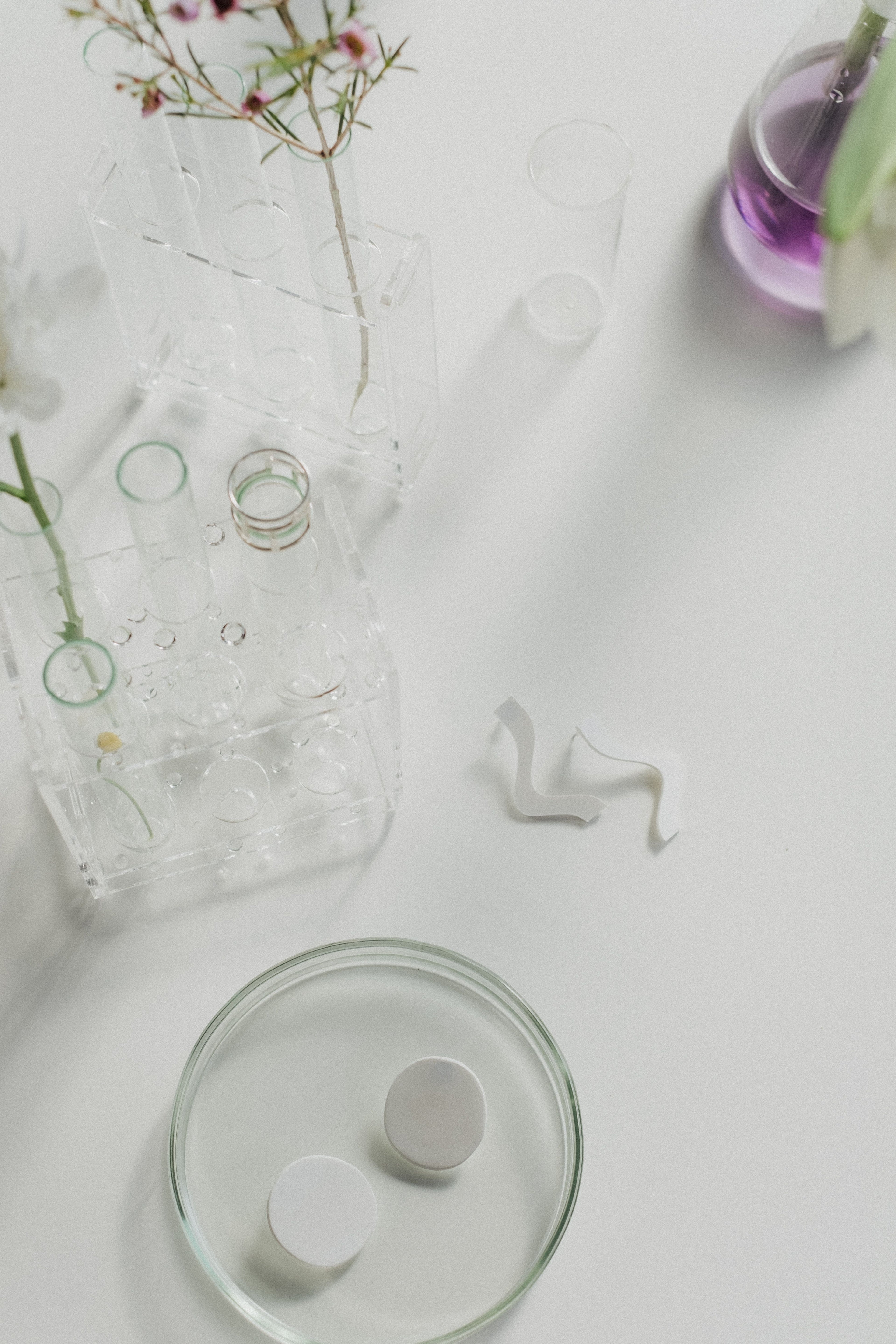 Minimalistische Skincare-Komposition mit Salicylsäure und Hautpflege-Produkten auf hellem Hintergrund
